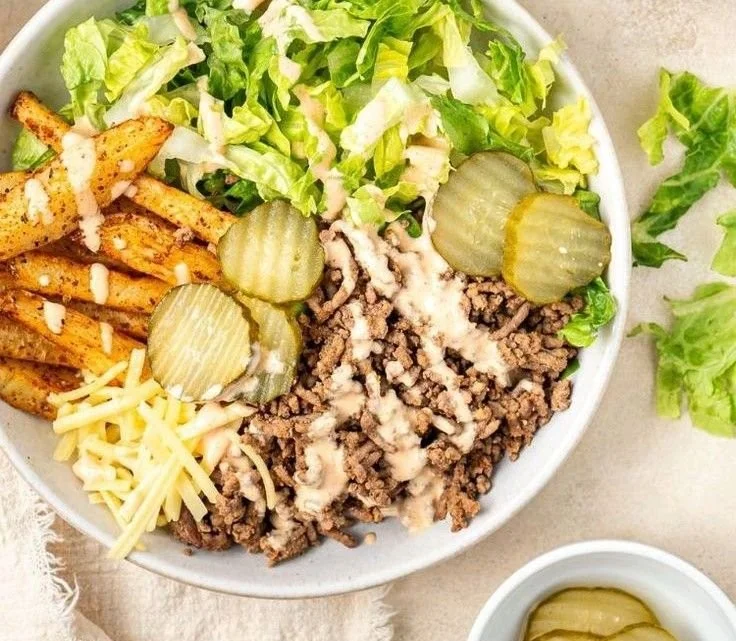 A colorful and appetizing burger bowl filled with fresh ingredients and toppings