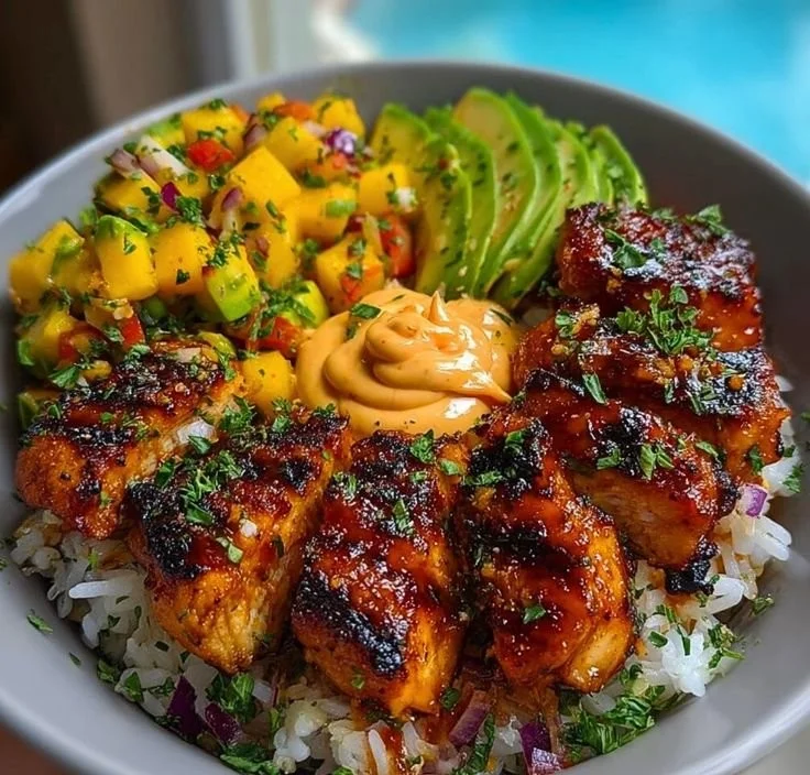 Grilled maple sriracha chicken bites served with coconut rice and mango avocado salsa